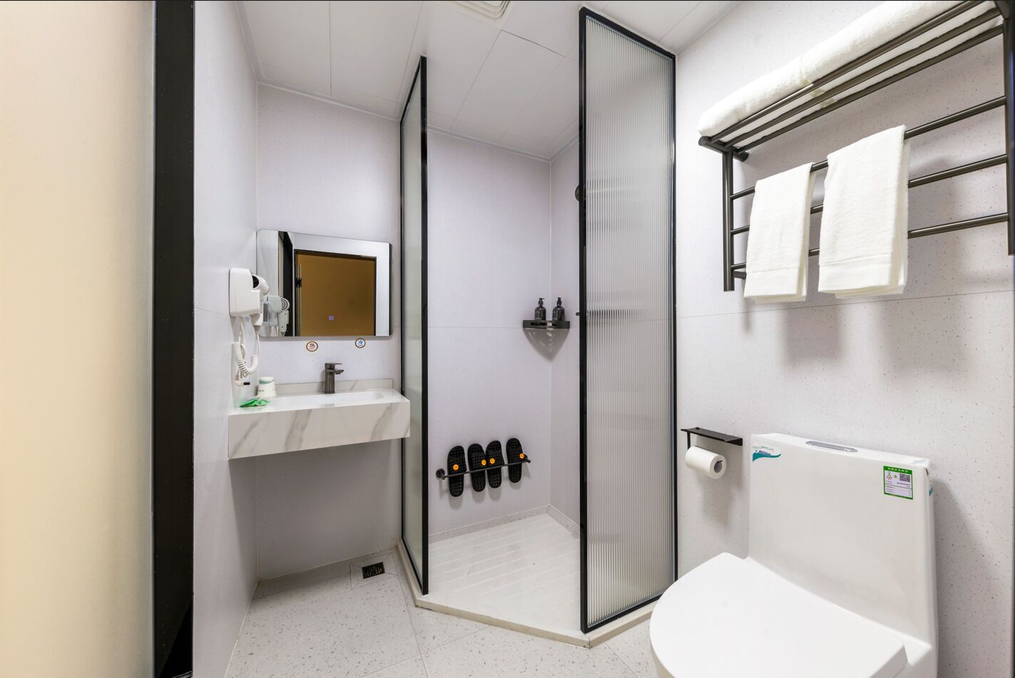Un baño moderno con ducha, inodoro y lavamanos.