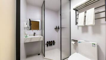 Un baño moderno con ducha, inodoro y lavamanos.