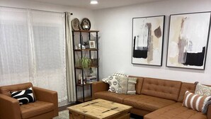 A living room with a brown sofa, a wooden coffee table, and a dog. - Wine Country Cottage Escape (Fulton)