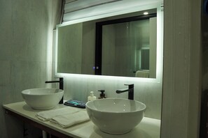 A modern bathroom with two large white vessel sinks, a mirror, and a towel rack. - 1 Min from MBJ Airport; Cozy Studio; AC; Wi-Fi (Montego Bay)
