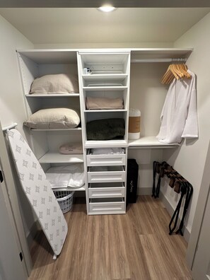 Ein begehbarer Kleiderschrank mit Regalen, Schubladen und Kleiderstangen.