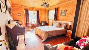 Une pièce chaleureuse, aménagée dans un chalet en bois, avec un lit, un bureau, une chaise et un canapé.