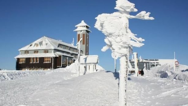 A snow-covered landscape with a building featuring a tower and a large snow sculpture. - Fewo Bergkristall by Interhome (Sehmatal)