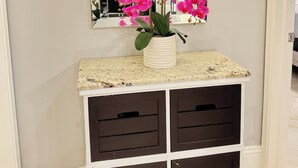 Un tocador de baño con espejo, una orquídea en maceta y una encimera.