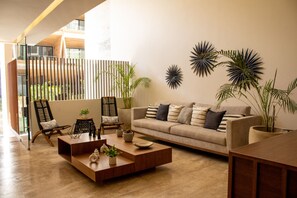 A modern living room with a sofa, chairs, a coffee table, and decorative plants. - Paravian 504 Playa del Carmen (Playa del Carmen)