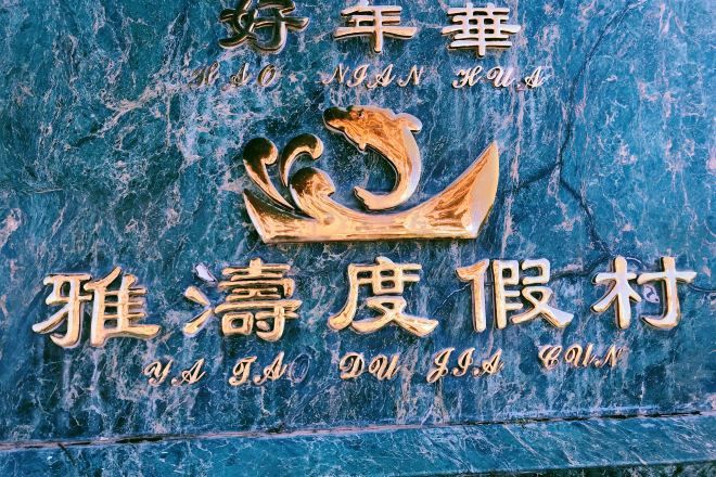 Una pared de mármol azul con un emblema dorado y caracteres chinos.