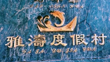 Una pared de mármol azul con un emblema dorado y caracteres chinos.