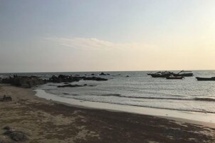 Una playa con barcos y rocas.