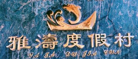 A sign with a logo and text, likely indicating a hotel or establishment.