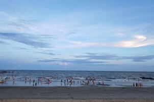 Una playa con gente y un mar tranquilo.