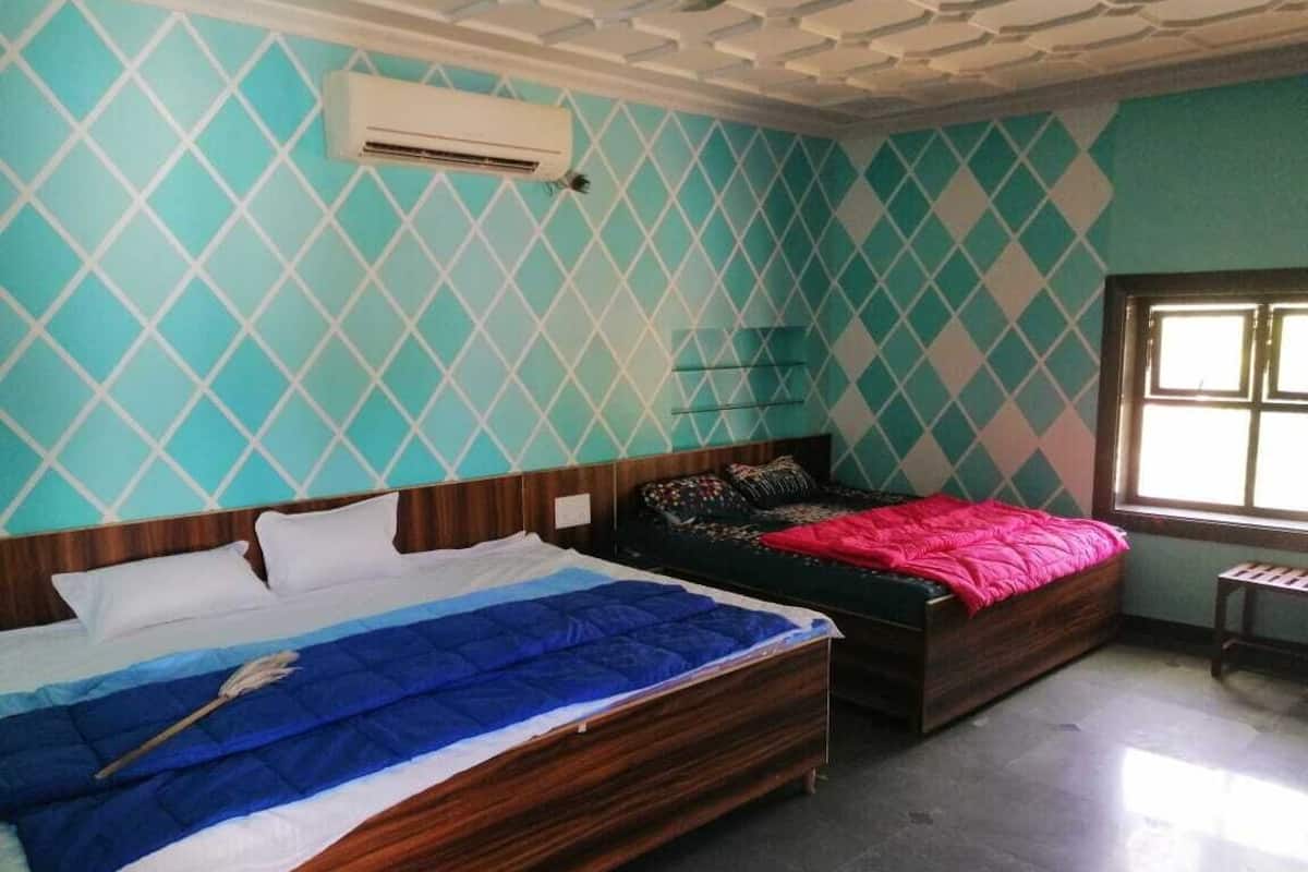 Une chambre avec deux lits, une fenêtre et un appareil de climatisation.