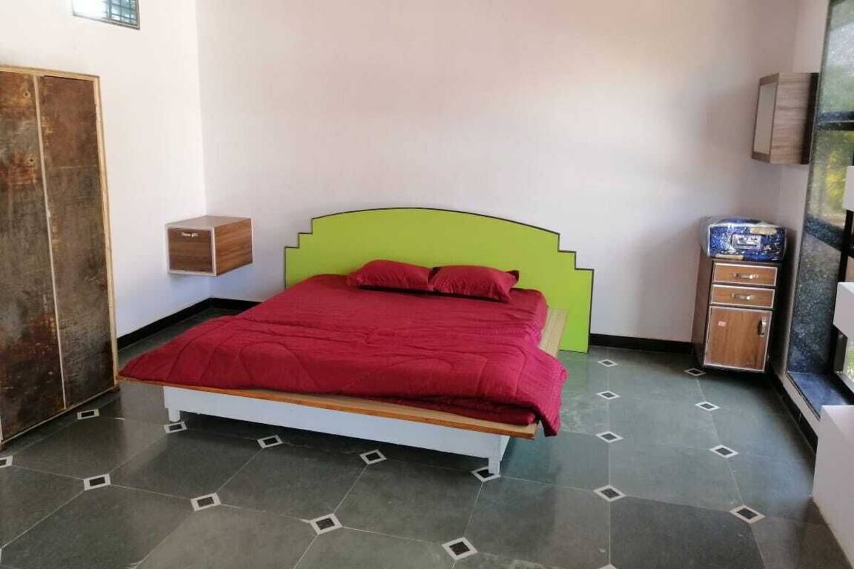 Une chambre à coucher avec un lit, une armoire et un petit meuble.