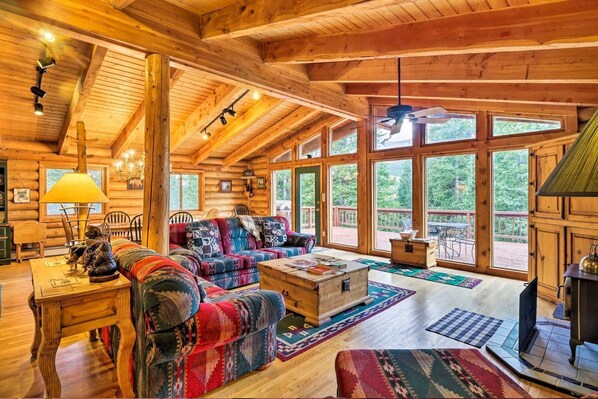 Ein rustikaler Innenraum einer Blockhütte mit einer Couch, einem Tisch und einem Kamin.