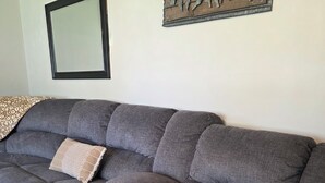 A sectional sofa with a built-in coffee table, a wall-mounted picture frame, and a decorative wall piece.