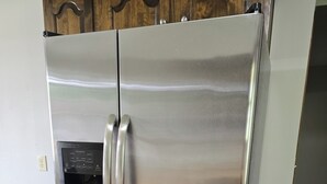 A stainless steel refrigerator with a built-in ice maker and a digital control panel.