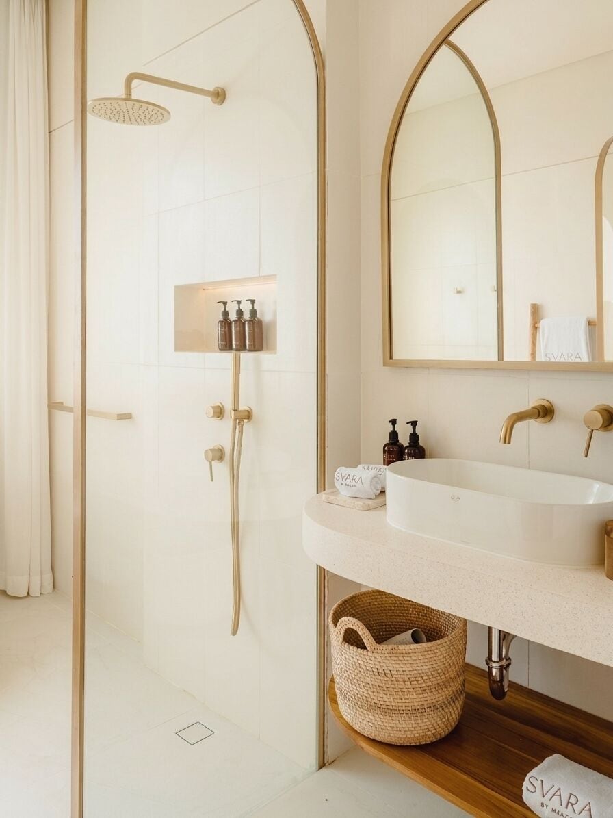 Ein modernes Badezimmer mit Bodendusche, einem großen Spiegel und einem Waschbecken mit Holzablage darunter.