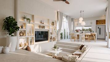 Ein modernes Wohnzimmer mit Flachbildfernseher, Deckenventilator und Essbereich mit Holzküchenmöbeln.