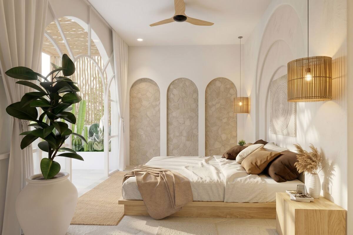 Un dormitorio con una cama, un ventilador de techo, una planta grande en maceta y vistas a través de una ventana.