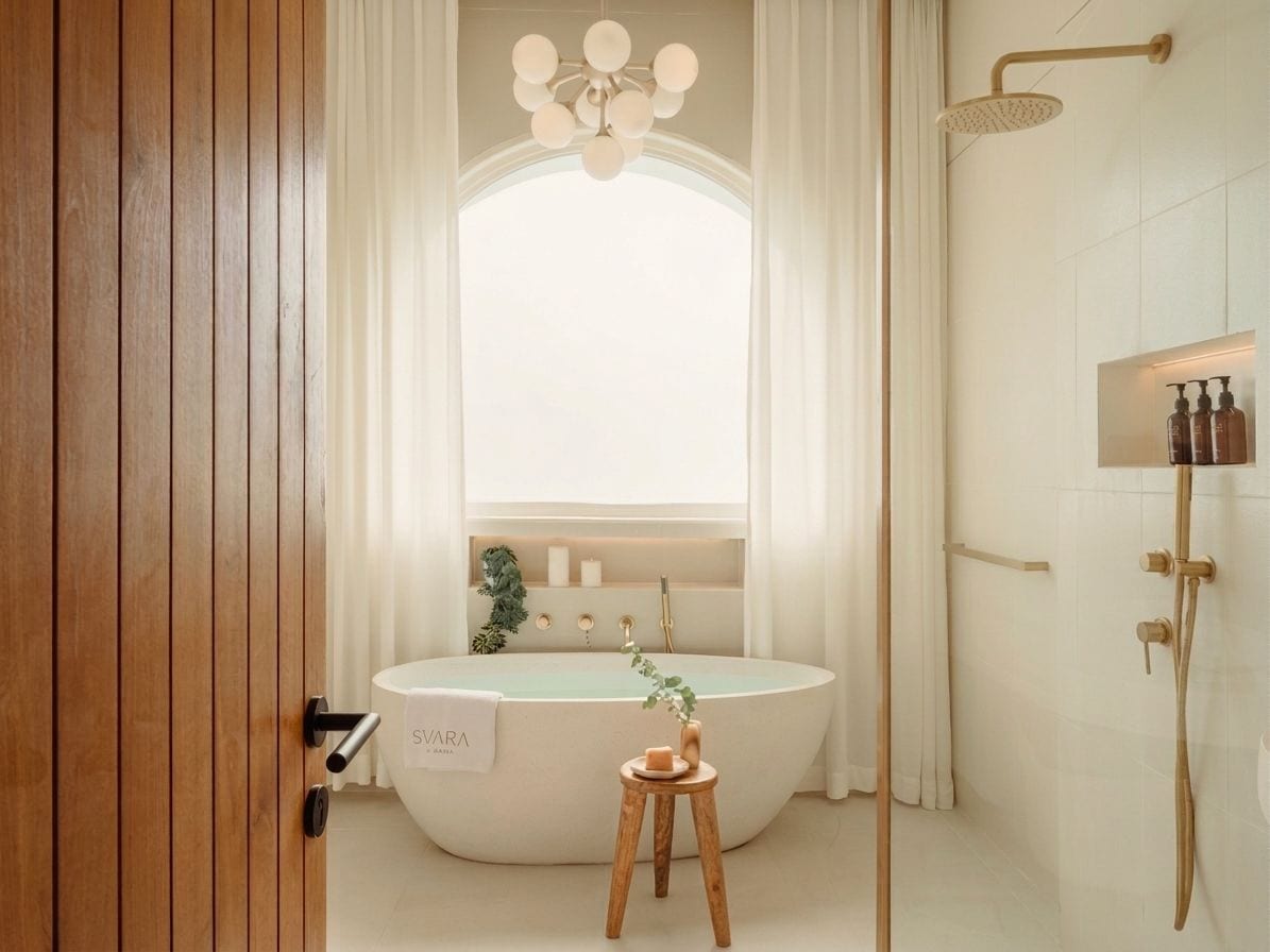 Un baño moderno con una bañera independiente, un cabezal de ducha y un tocador con artículos de aseo.