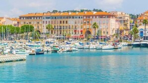 A marina with boats docked, buildings with orange roofs, and palm trees. - 4* - sea view - 2 bedrooms - parking - swimming pool (Saint-Raphaël)