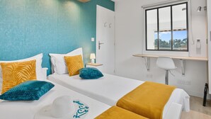 A modern hotel room with two beds, a desk, and a window with a view. - 4* - sea view - 2 bedrooms - parking - swimming pool (Saint-Raphaël)