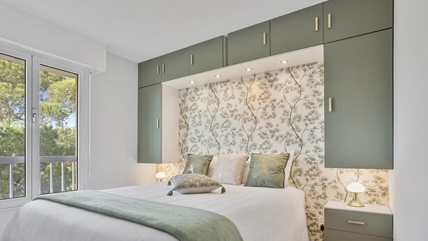 A bedroom with a large bed, a nightstand, a dresser, and a window with a view of trees. - 4* - sea view - 2 bedrooms - parking - swimming pool (Saint-Raphaël)