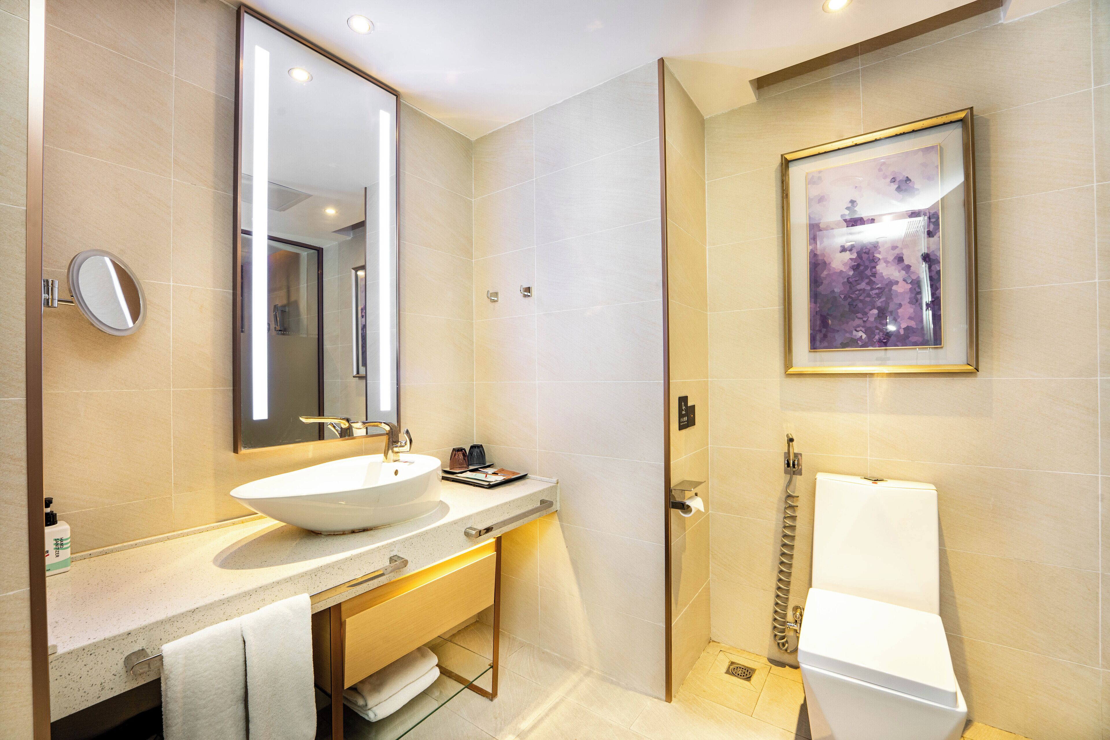 A modern bathroom with a large sink, mirror, and toilet.