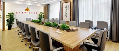 A conference room with a long table, chairs, and a projector.
