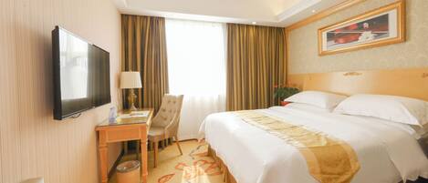 A hotel room with a bed, a desk, a chair, a television, and a painting on the wall.