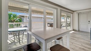 Une pièce spacieuse avec une grande fenêtre, une table en bois et une chaise.