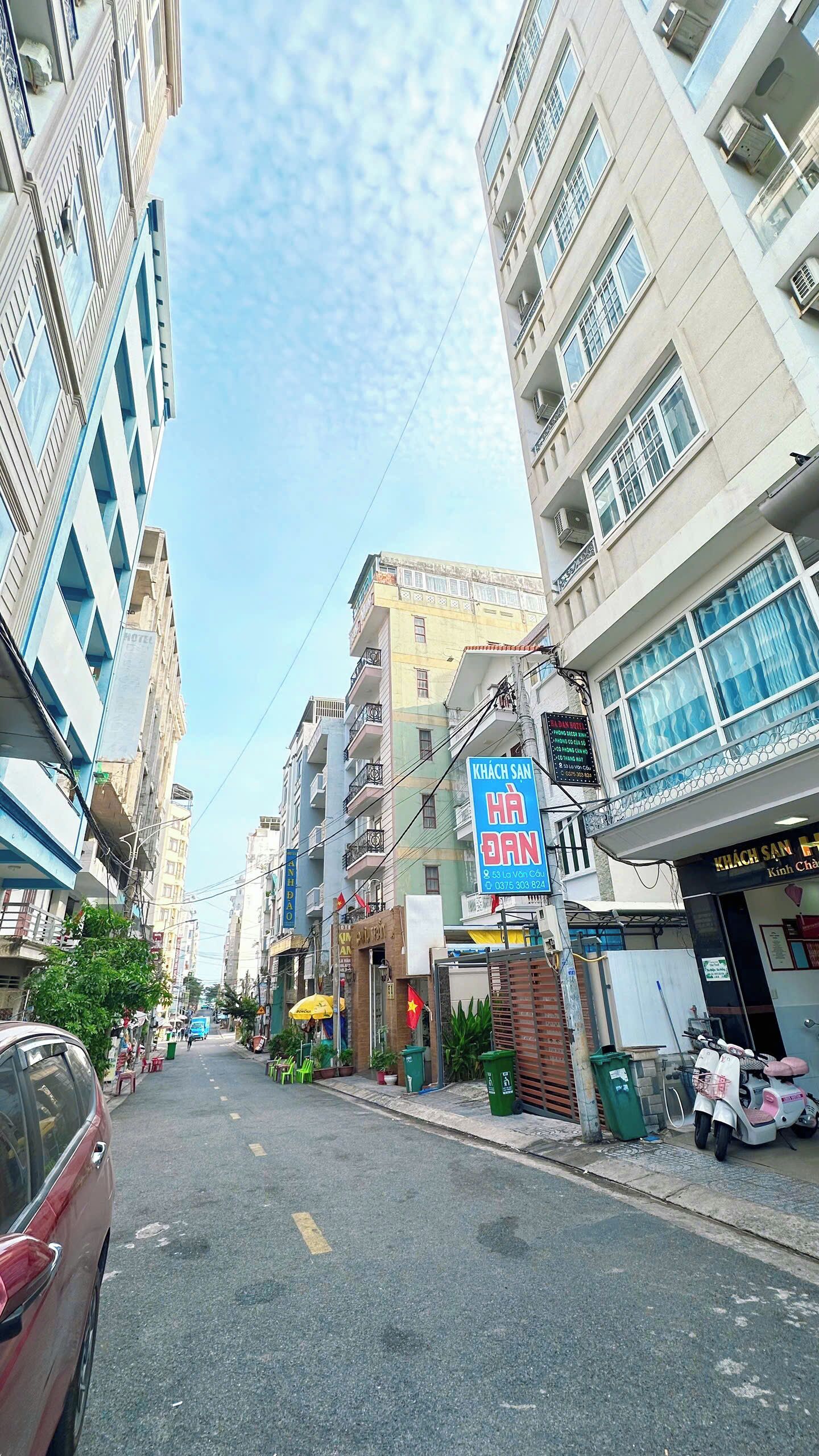 A street view with a building labeled "KHÁCH SAN" and a sign for "HOTEL".