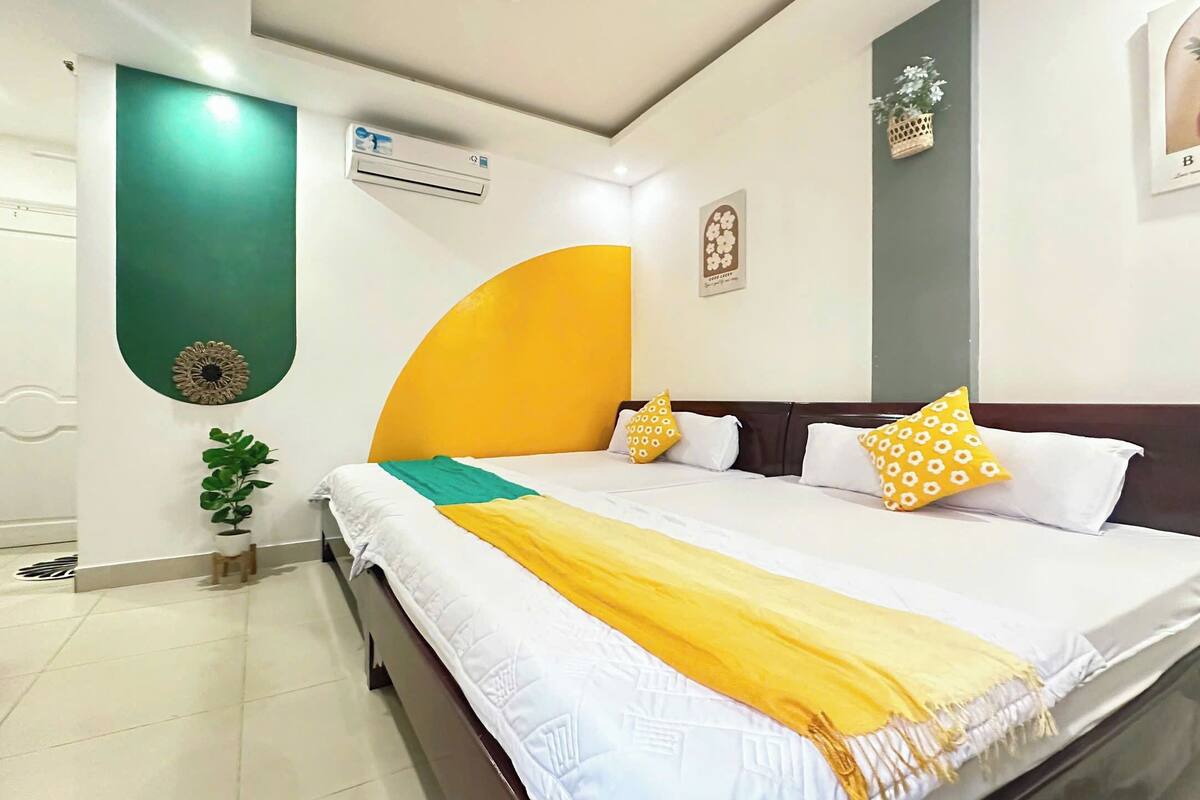 Ein Hotelzimmer mit einem Bett, einer Topfpflanze und einer Wand-Klimaanlage.