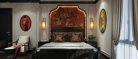 Quarto com uma cama grande, uma cadeira, um criado-mudo e uma cabeceira floral na parede.