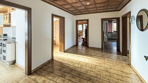 Um corredor amplo com piso de madeira e teto alto com padrão de grade.