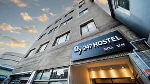 Un hostal con un letrero que indica que se encuentra en el número 247, Seúl, 3er y 4to piso.