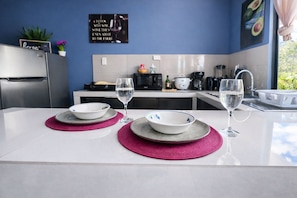 A modern kitchen with a dining area set for two.