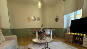 Ein gemütliches Wohnzimmer mit einer Couch, einem runden Tisch und einem Fernseher.