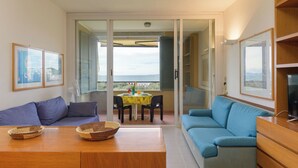 A modern living room with a sofa, a dining table with chairs, and a balcony with a view. - Boboli2 by Interhome (Punta Ala)