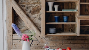 A rustic wooden table with a floral arrangement, a pitcher, and a plate of vegetables. - Quiet apartment above the Bobertal valley in the foothills of the Giant Mountains (Tarczyn)