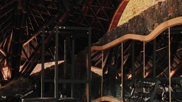 Une salle de sport équipée de matériel d’exercice, avec un mur en pierre et une structure de plafond en bois.