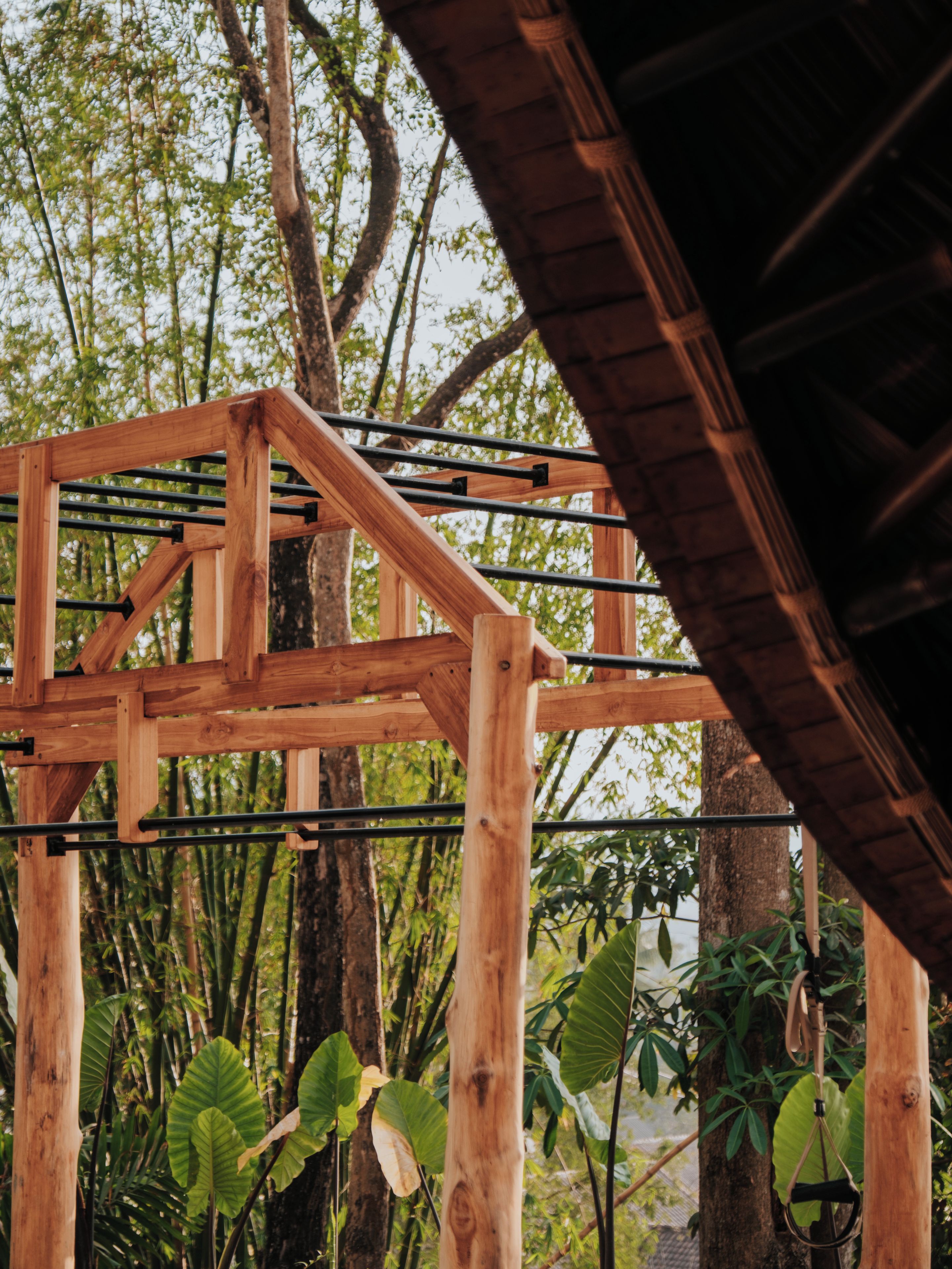 A wooden structure with metal bars, surrounded by trees and foliage.