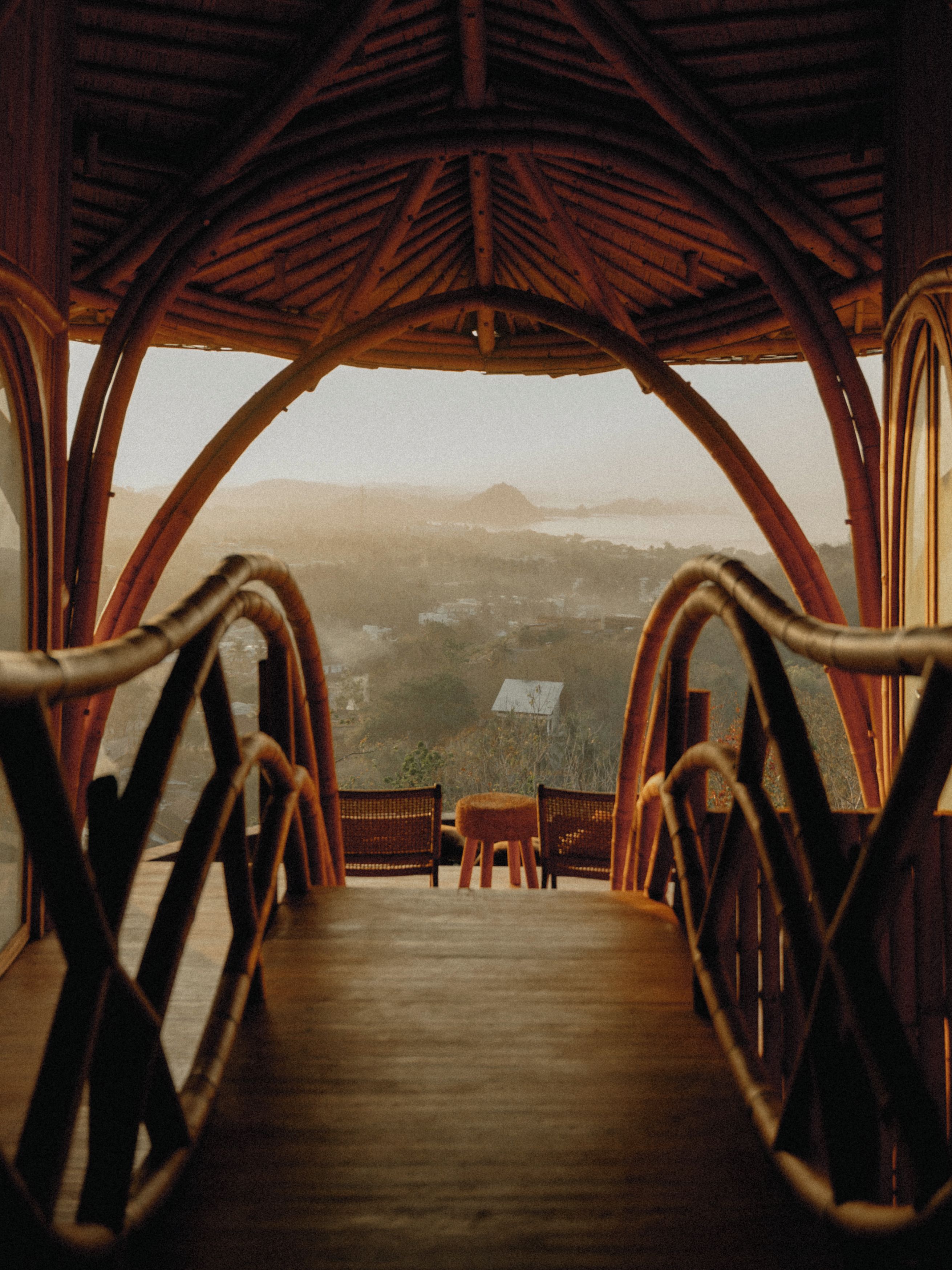 A wooden interior with a view of a landscape through a large window.