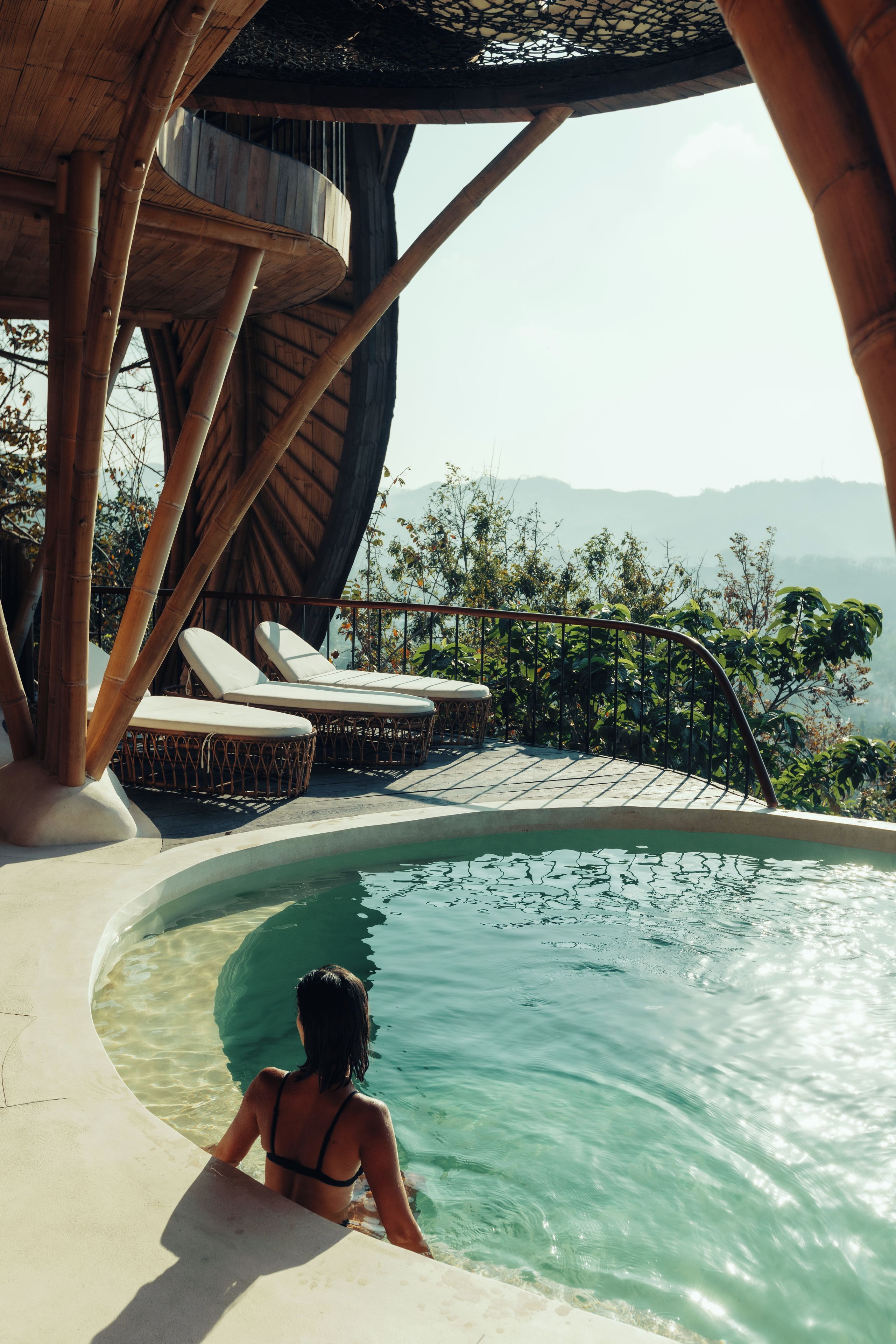 Una persona en una piscina con vistas a montañas.