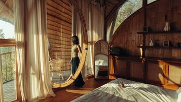 Una habitación con cama, una silla y un espejo grande.