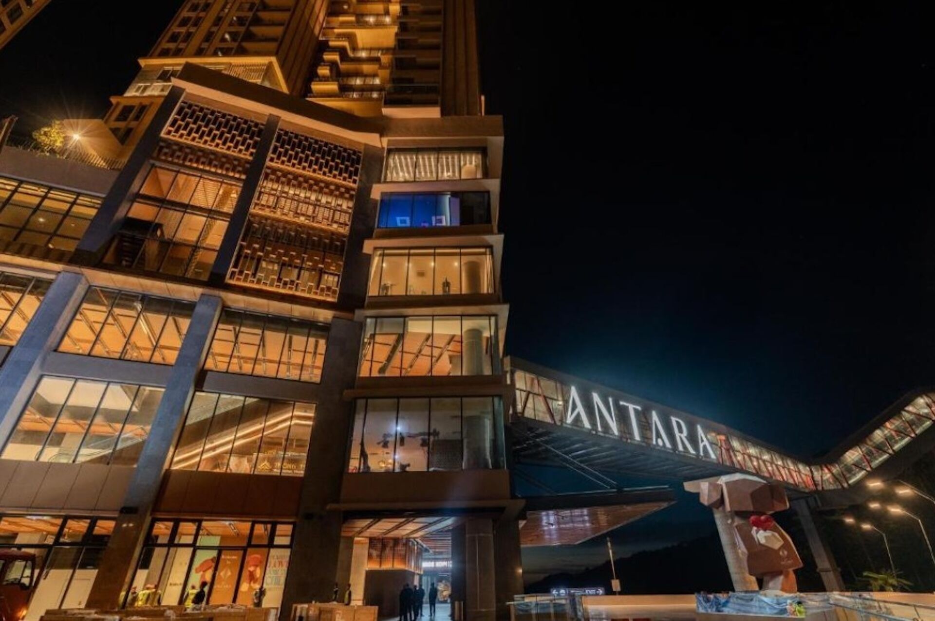 A modern building with a prominent 'ANTARA' sign, featuring a unique architectural design with multiple levels and large windows.
