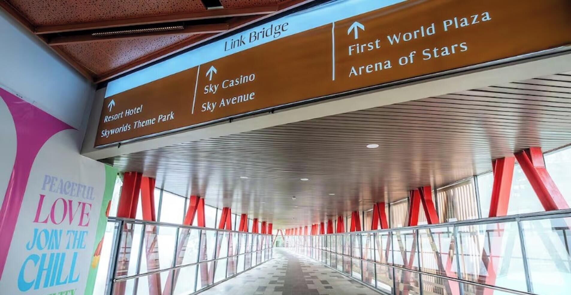 A corridor with directional signs pointing to various locations including Sky Casino, Sky Avenue, and First World Plaza.