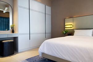 Un dormitorio moderno con una cama grande, un tocador con espejo y un armario.