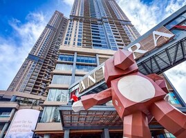 A tall building with a prominent red sculpture in front.