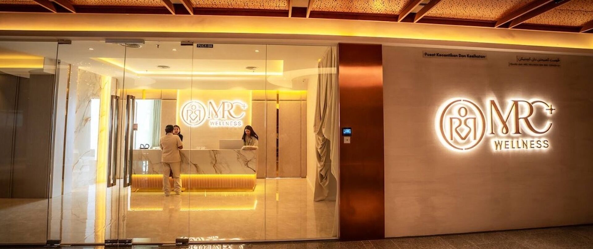 A modern wellness center with a glass entrance and a prominent logo.