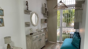 Un dormitorio con cama, cómoda, tocador, espejo y ventana con vistas al exterior.